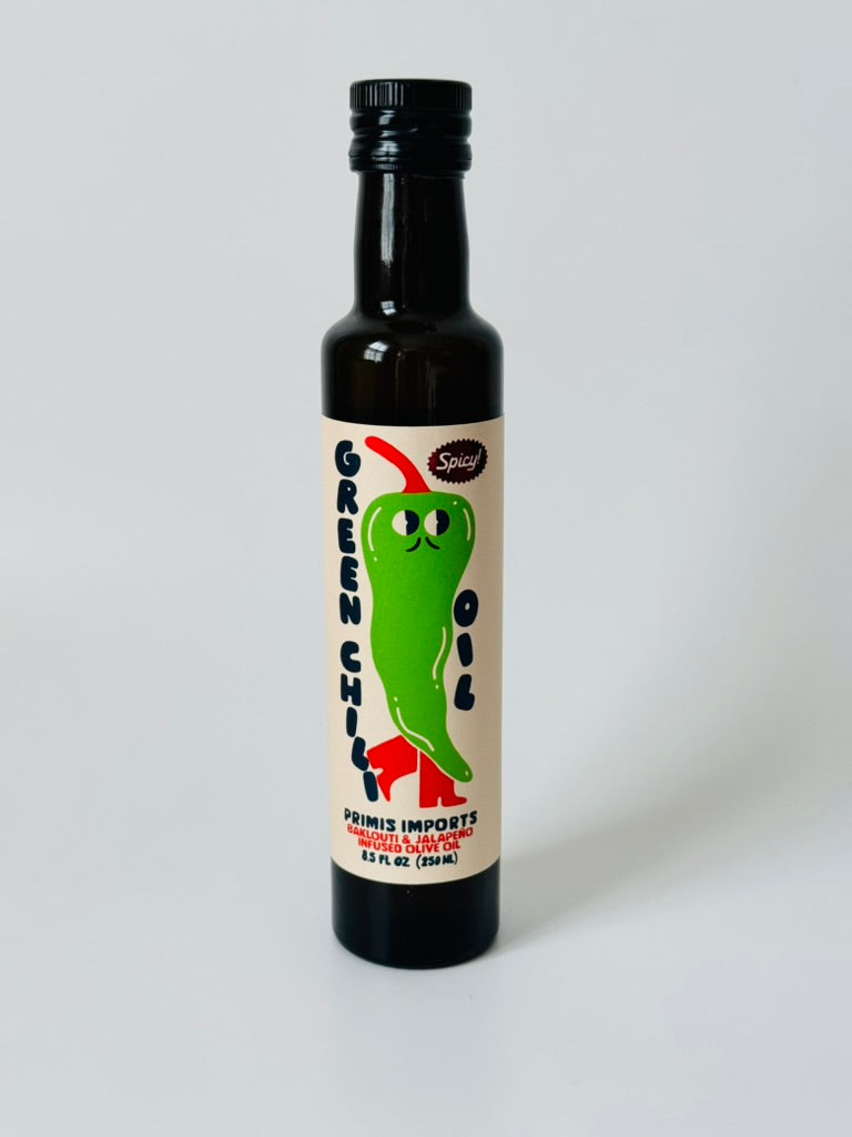 Bottle of green chili oil with a label on a white background